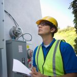 Maintenance worker reading meter of solar generation unit in Los Angeles; California